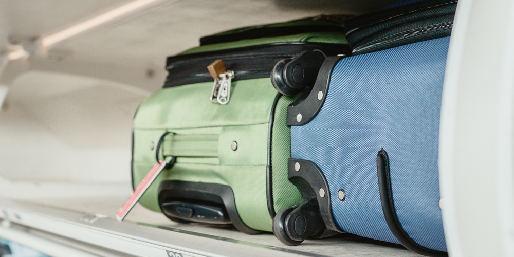 grüner, blauer Trolley, Gepäckfach, Flugzeugkabine, kompaktes Handgepäck