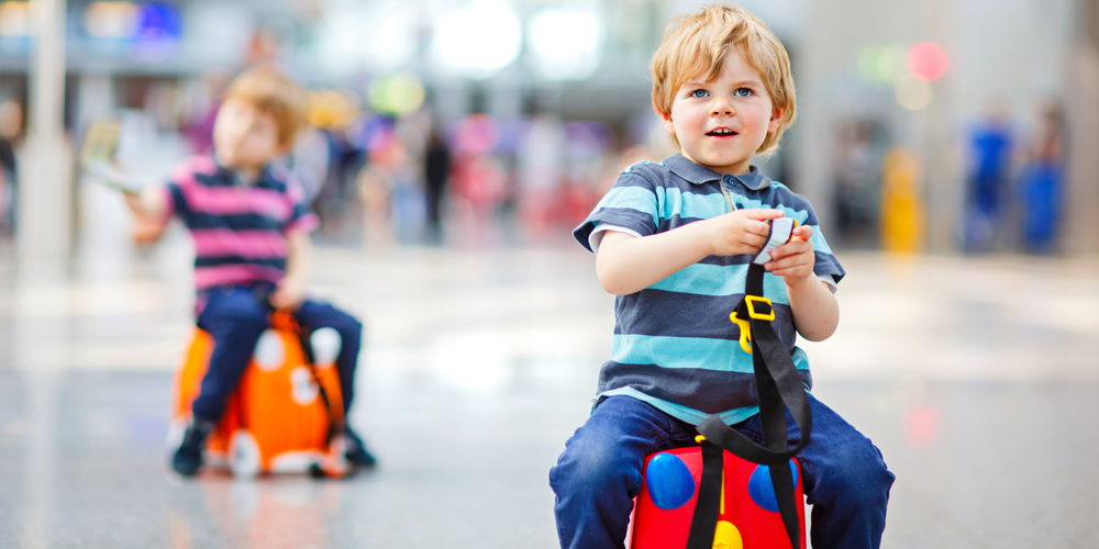 Kindertrolley, Kind sitzt darauf, bunt, verspielt, Reise mit Kindern, Spaß unterwegs