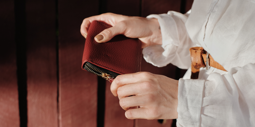 kleine rote Damenbörse, mit goldfarbenem Reißverschluss, helle Bluse