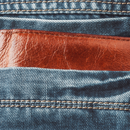 braune Lederbörse, steckt in Gesäßtasche aus Jeansstoff