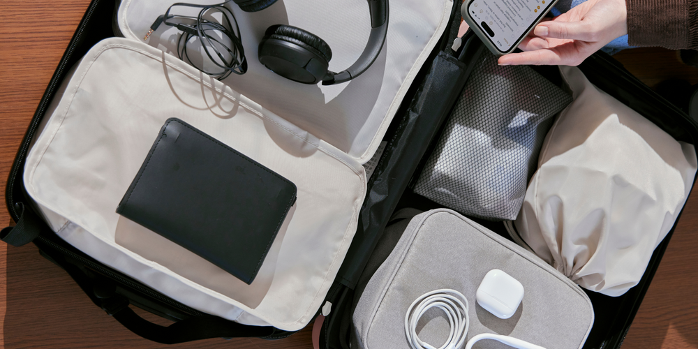 Reisezubehör, Koffer geöffnet, Kopfhörer, Kabel, Ladegeräte, Handy, praktisch organisiert