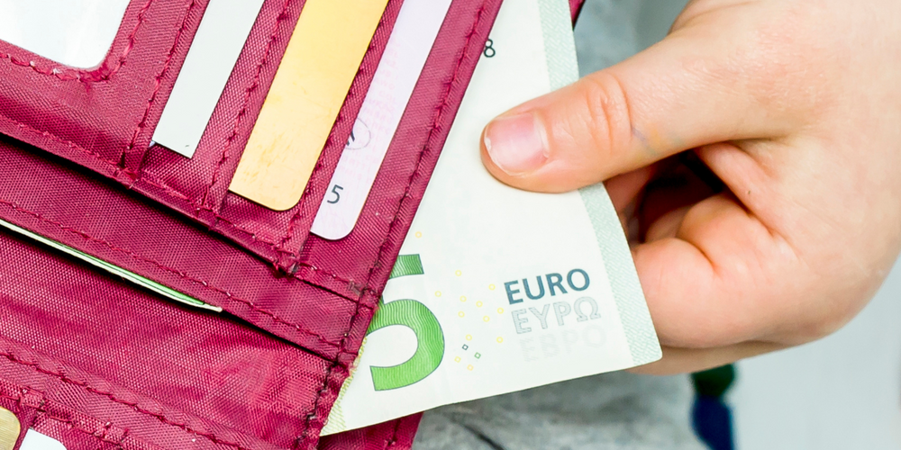 Brustbeutel, geöffnet, rote Farbe, Hand mit 5-Euro-Schein, Kartenfächer sichtbar, Nahaufnahme