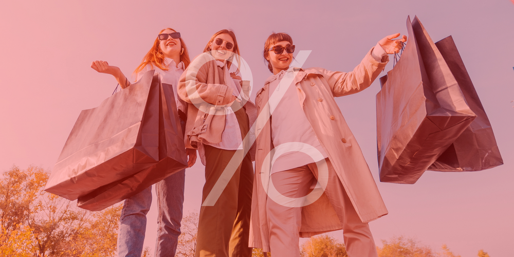 Sale Damen, zwei Frauen mit großen Einkaufstüten, lachend, Sonnenbrillen, Prozentzeichen über dem Bild, warmes Licht