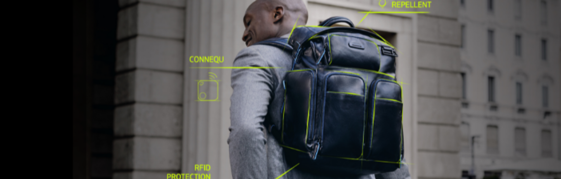 Piquadro, schwarzer Business-Rucksack, Mann im Anzug, Rückenansicht, urbane Umgebung, technologische Features grafisch hervorgehoben