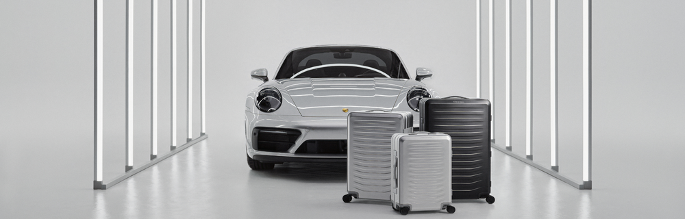 Porsche Design, Trolleys, Aluminium-Koffer, silber und schwarz, Sportwagen im Hintergrund, High-End Design
